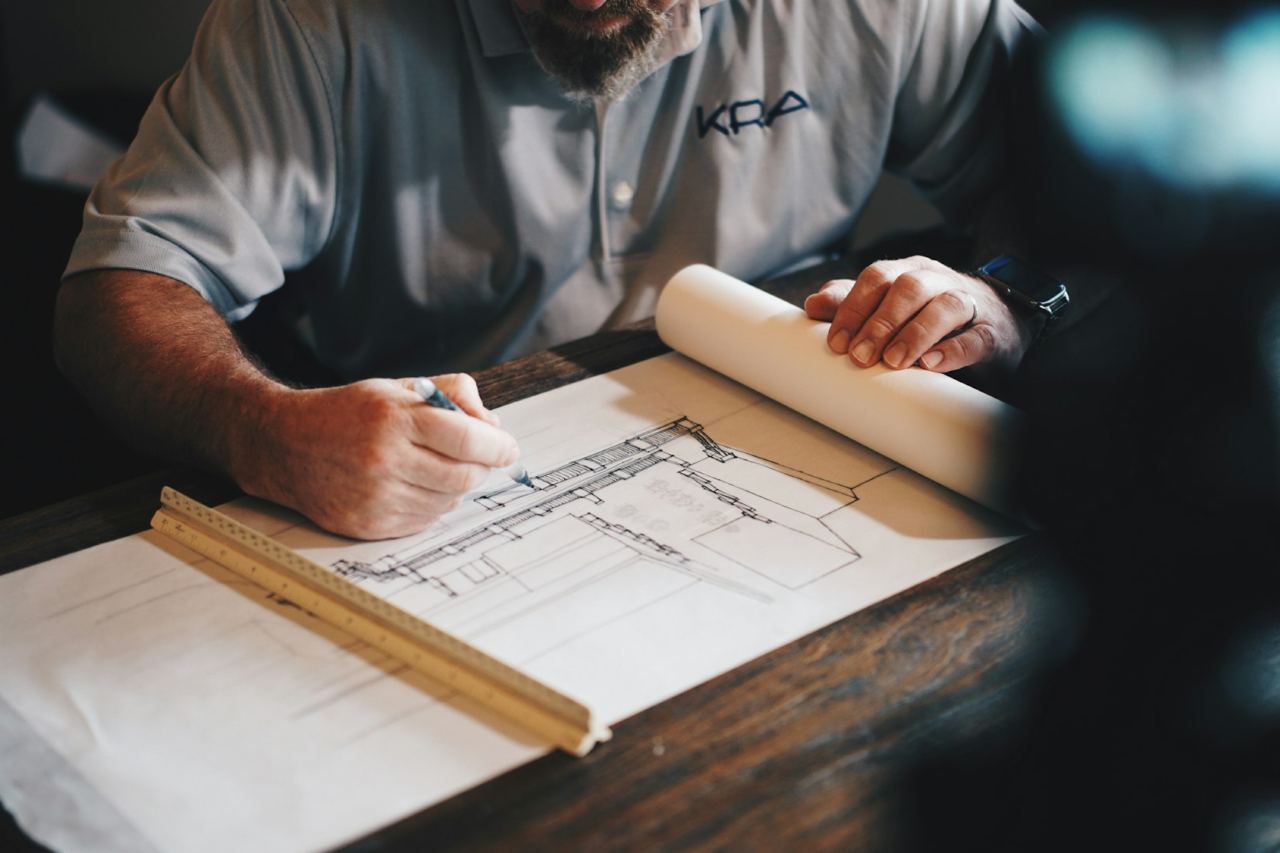 Engenheiro a rever desenhos técnicos sobre uma mesa